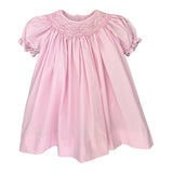 Pink dress with smocked neckline on a white background