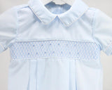 Light blue shirt with white collar and intricate white embroidery on a plain background