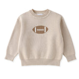 A beige knit crewneck sweater with a brown and white football graphic on the chest, displayed flat against a white background.