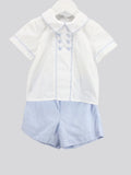 A two-piece children's outfit set consisting of a white short-sleeve collared shirt with light blue piping and decorative buttons, paired with light blue and white pinstriped shorts, shown on a hanger against a solid gray background.