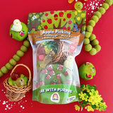 Play dough kit with apple-themed toys on a red background.