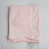 Pink quilted blanket on a white background