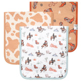 Set of three burp cloths with cowboy patterns on a white background