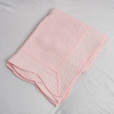 Pink quilted blanket on a white background