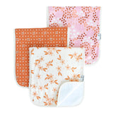 Three baby burp cloths with floral and polka dot patterns on a white background