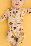 Baby wearing a onesie with breakfast food-themed print on a yellow background